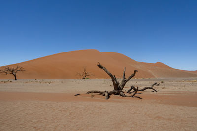 Scenic view of desert against clear blue sky