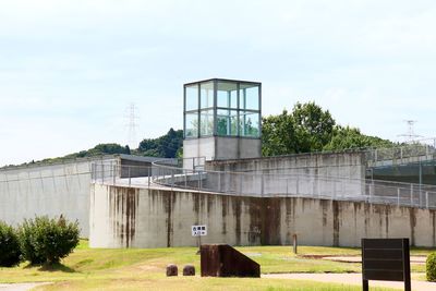 Built structure on field by building against sky