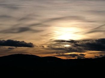 Scenic view of dramatic sky over silhouette landscape