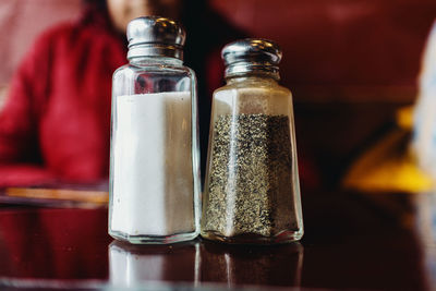 Salt and pepper shakers on restaurant table.