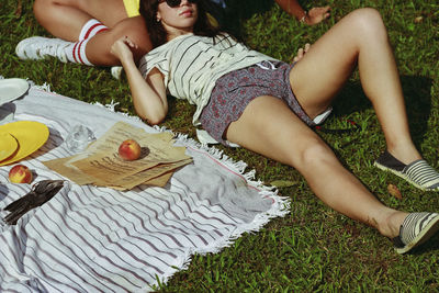 High angle view of woman lying on friends at park