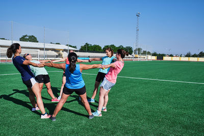 Group of young women practice stretching after their training