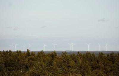 Landscape with wind turbines in distance against clear sky