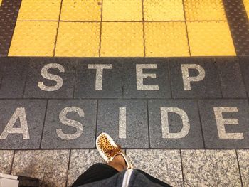 Low section of woman standing on tiled floor