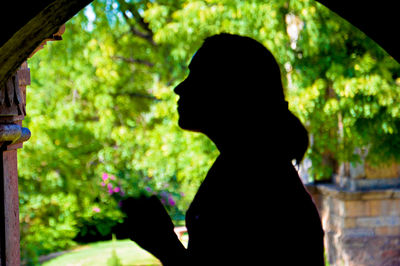 Rear view of silhouette woman standing against blurred background