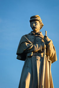 Low angle view of statue against blue sky