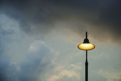 Low angle view of street light against cloudy sky