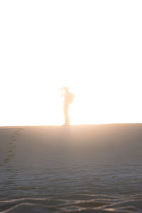 Man standing on beach against clear sky