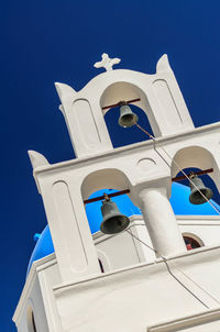 Low angle view of bell tower against blue sky