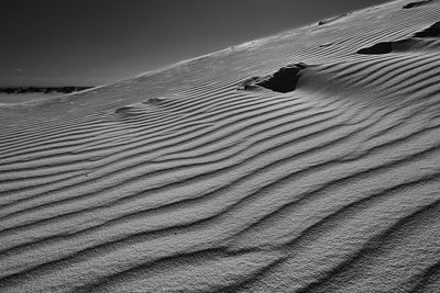 Sand dune in desert against sky