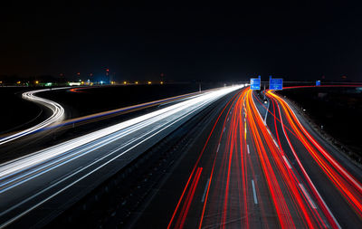 Light trails on roads against clear sky at night
