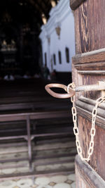 Close-up of rope tied to wooden door of building