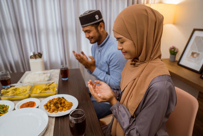 Couple praying while having food at home