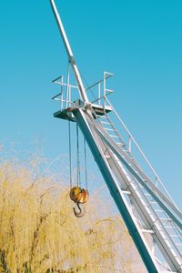 Low angle view of wind turbine against clear blue sky