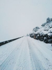 Snow covered road against clear sky