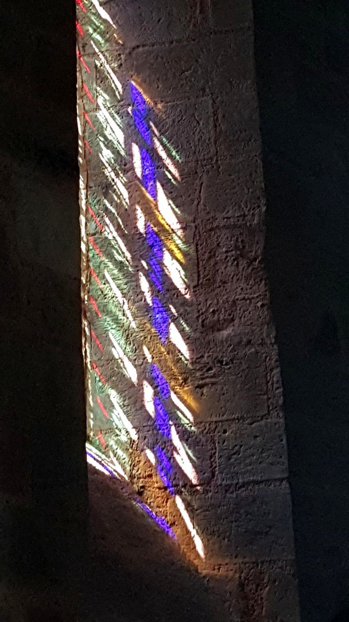 LOW ANGLE VIEW OF ILLUMINATED LIGHTS AGAINST BUILDING WALL