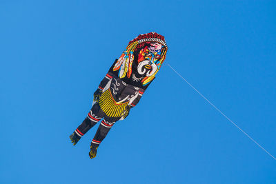 Low angle view of kite flying against clear blue sky