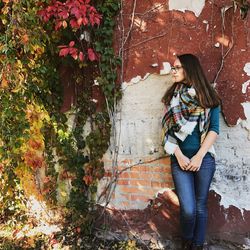 Full length of young woman standing against tree