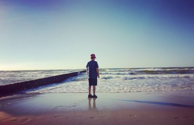 Full length of man standing on beach against clear sky