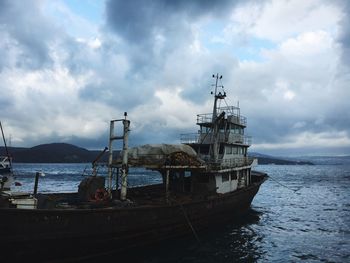 Boat moored on sea against sky