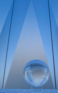 Low angle view of glass against blue sky