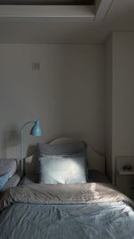 Electric lamp on bed against wall at home