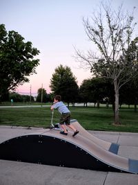 Rear view of woman standing on park bench in park