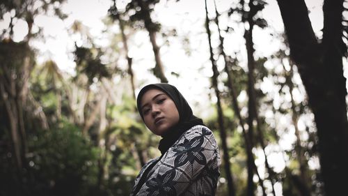 Portrait of young man looking away in forest