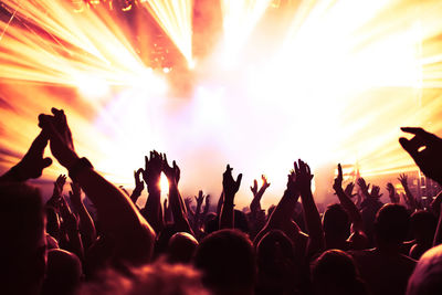 Group of people with arms raised at music concert