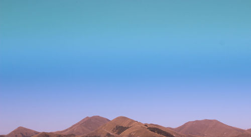 Scenic view of mountains against clear blue sky