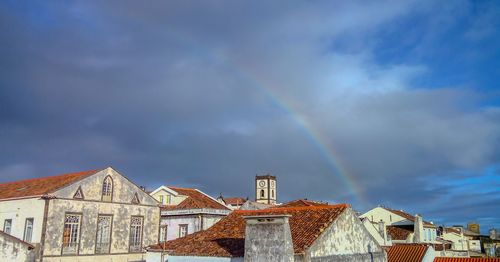 Low angle view of rainbow over buildings in city