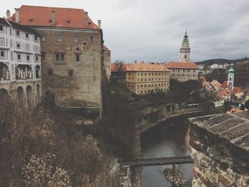 Arch bridge over canal amidst buildings in city