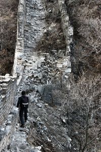 Rear view of man walking on snow covered mountain