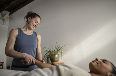 A female massage therapist works on an african american female client