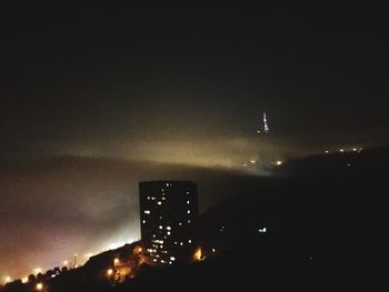 Low angle view of illuminated city against sky at night