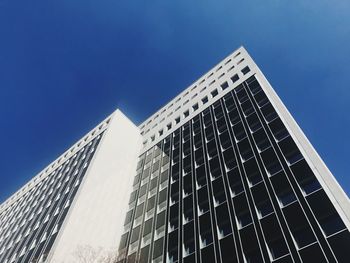 Low angle view of modern building against clear blue sky