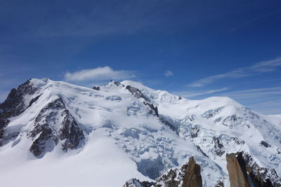 Scenic view of snowcapped mountains against blue sky