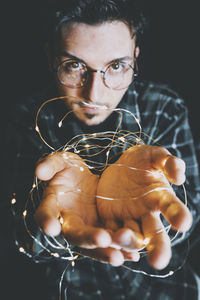 Close-up of man holding string light