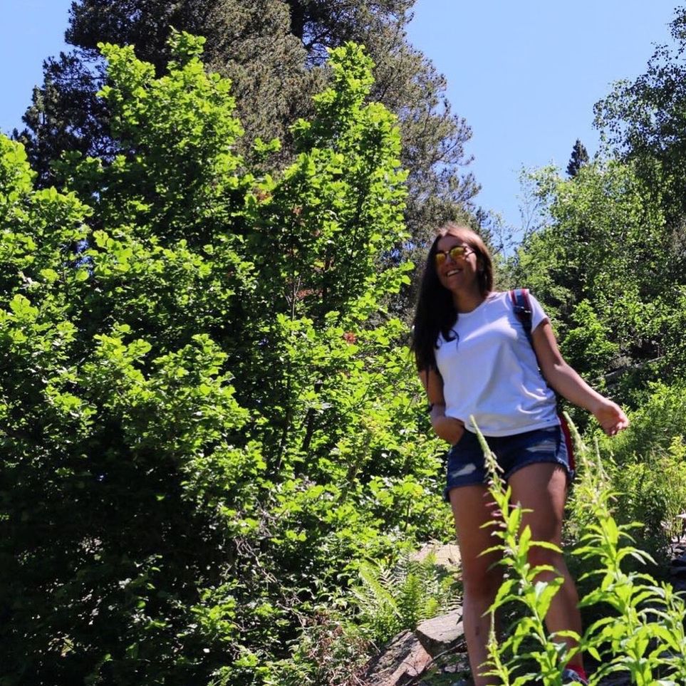 YOUNG WOMAN STANDING ON TREE TRUNK