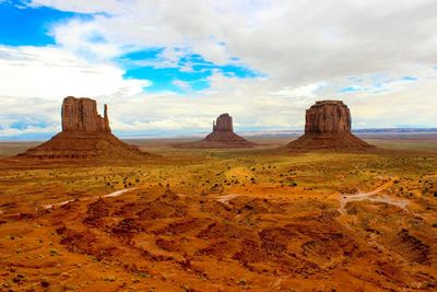 Scenic view of the mittens at monument valley against cloudy sky