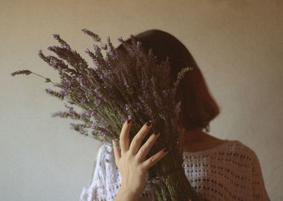 Portrait of woman against purple wall