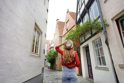 Attractive traveler woman walking in schnoor neighborhood, bremen, germany