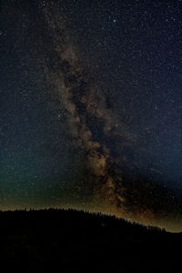 Low angle view of silhouette mountain against sky at night