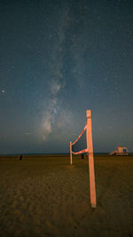 Lifeguard hut on beach against sky at night