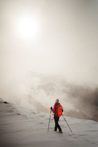 Rear view of man standing on snow covered landscape