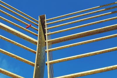 Low angle view of electricity pylon against clear blue sky