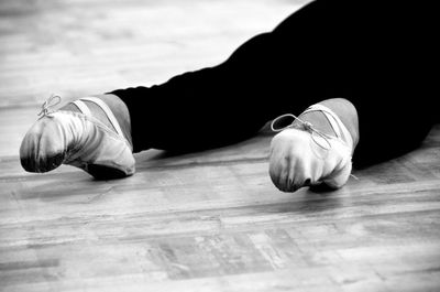 Low section of ballerina lying on floor