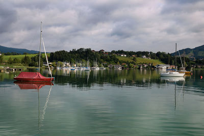 Boats moored in lake against sky