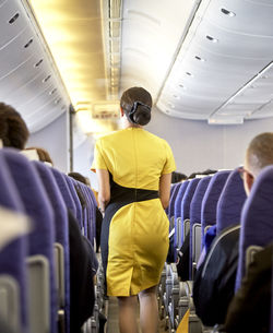 Rear view of airhostess in airplane