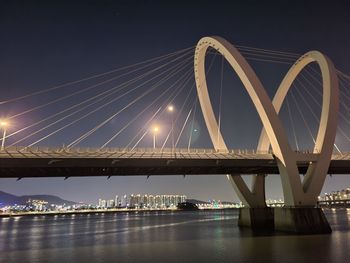 Low angle view of bridge over river at night